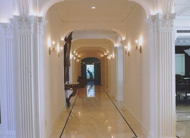 A luxury hallway with crown molding and white walls