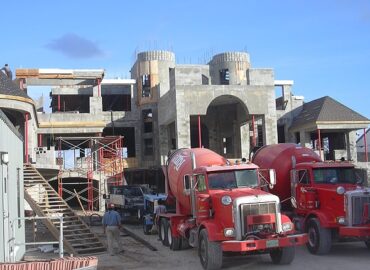 A home under construction with two red trucks